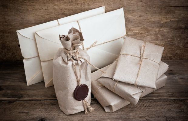 Paquetes envueltos en papel de estraza y atados con cordel sobre una mesa de madera