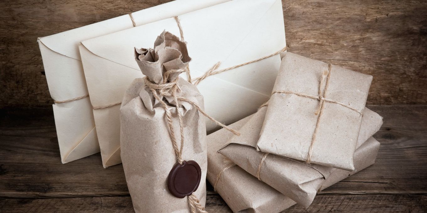 Paquetes envueltos en papel de estraza y atados con cordel sobre una mesa de madera